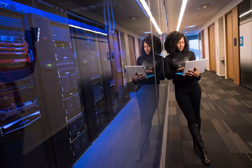 Analyst reviewing code on multiple monitors